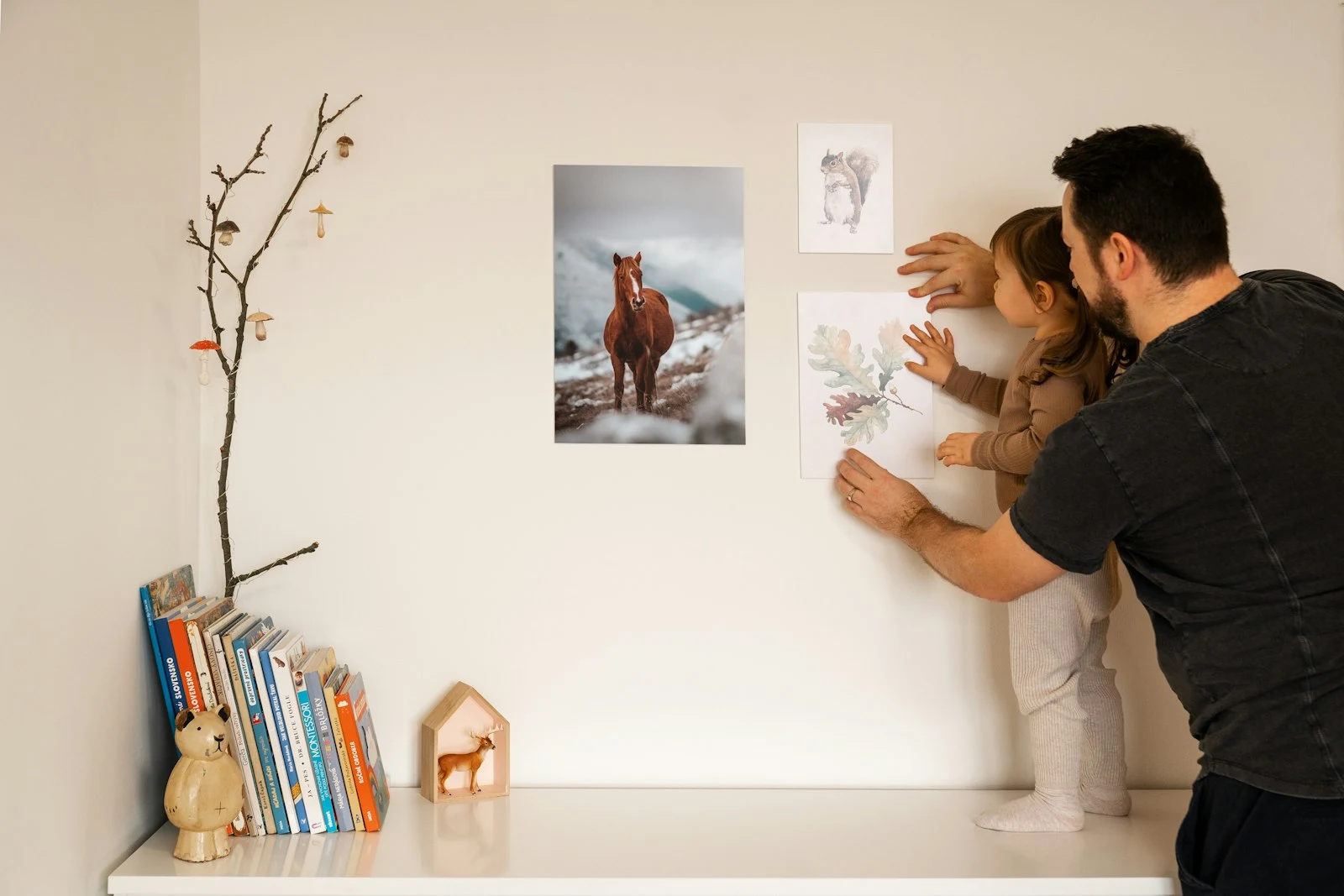 Family reviewing portrait photos displayed on a studio wall during an in-person sales session