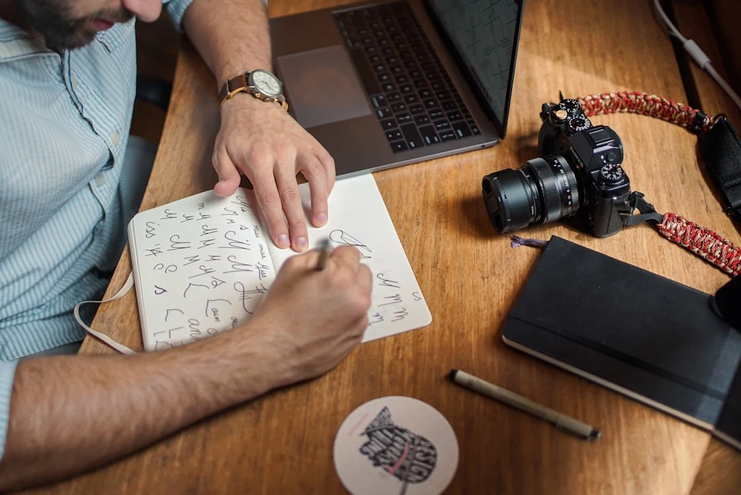 photographer planning their 30-day marketing launch at a desk with notebook